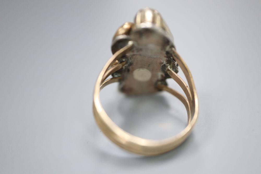 An early 20th century Arts & Crafts yellow and white metal and two stone cabochon coral set triple shank dress ring, size O,